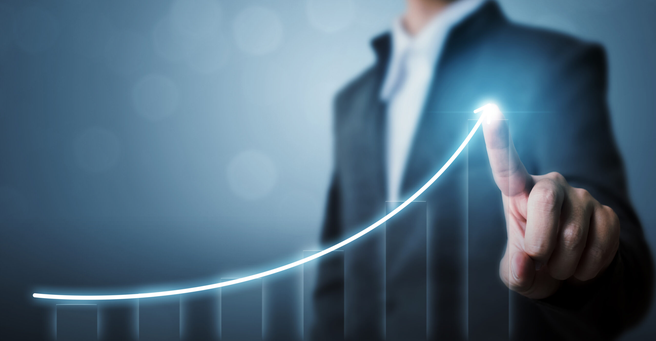 Business professional interacts with a glowing upward graph, symbolizing growth and success in financial or strategic planning.